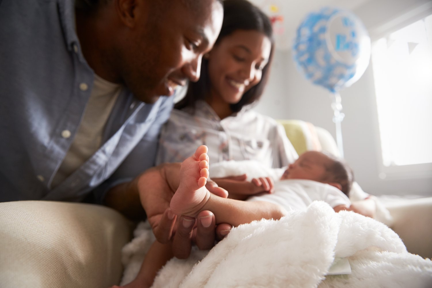 Newborn with a caregiver, representing early-life screening and follow-up.